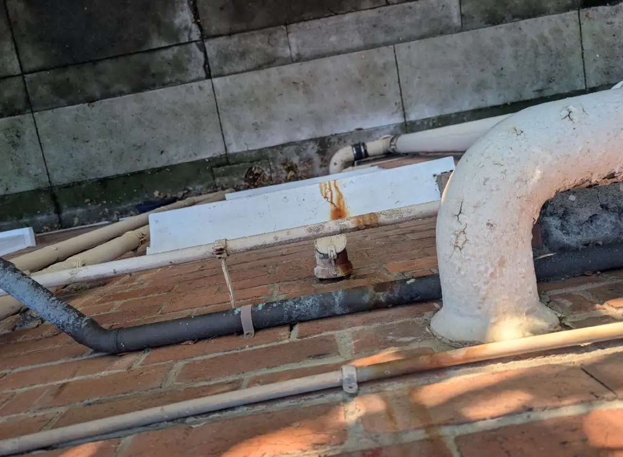 Pipe installation and plumbing system on brick wall.