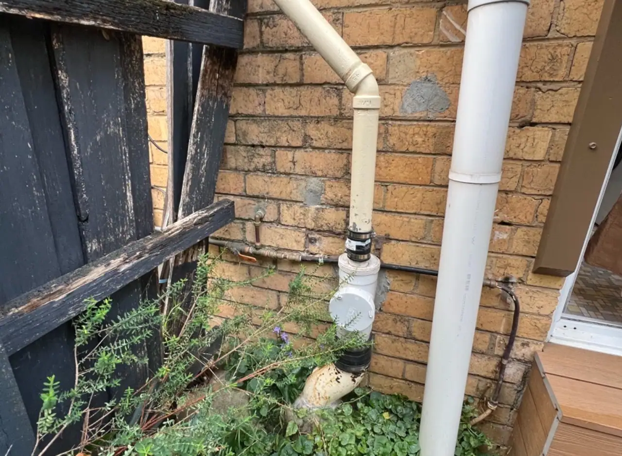 Drainage pipe and plumbing system on exterior brick wall.