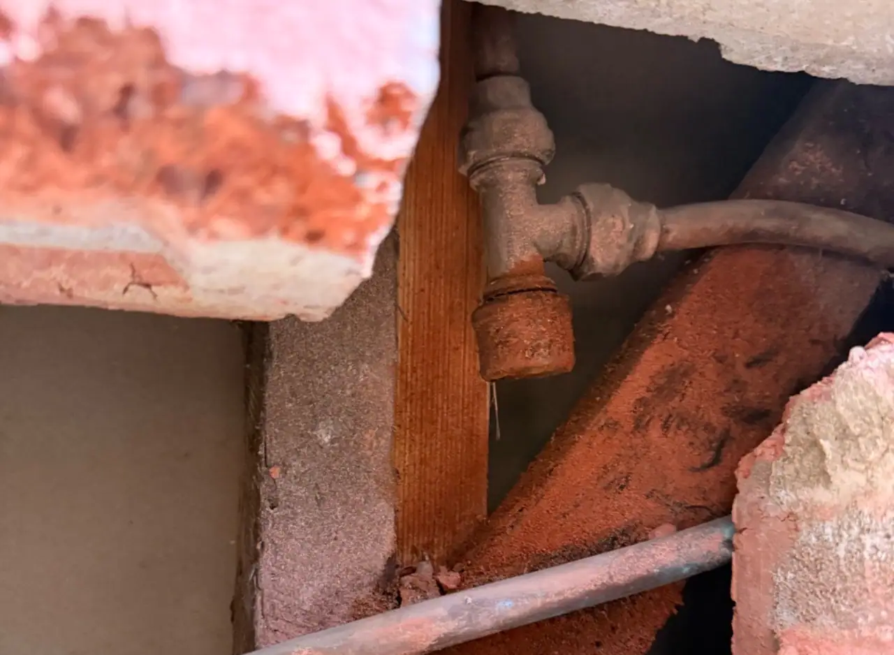 Rusty pipe and fittings showing a burst pipe leak in Richmond.