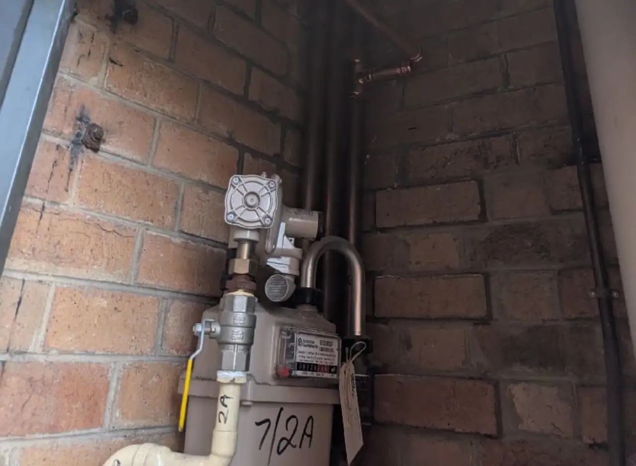Gas hot water system installed with pipes and valves in Richmond property.