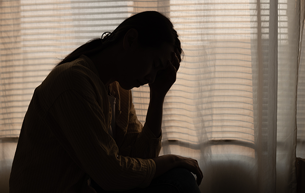 silhouette-of-sad-woman-sitting-by-window