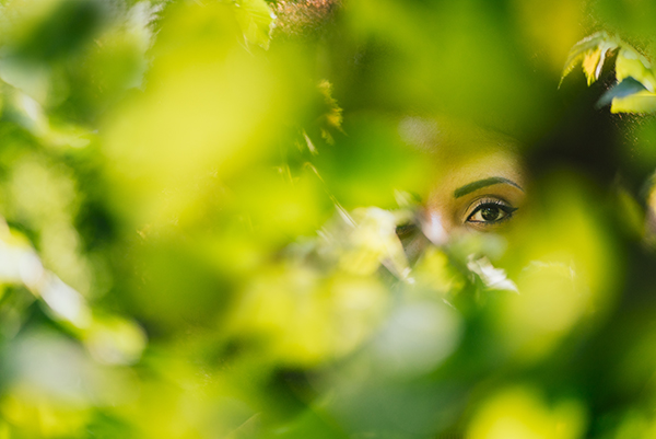 Nice portrait of beautiful afro woman through the leaves.