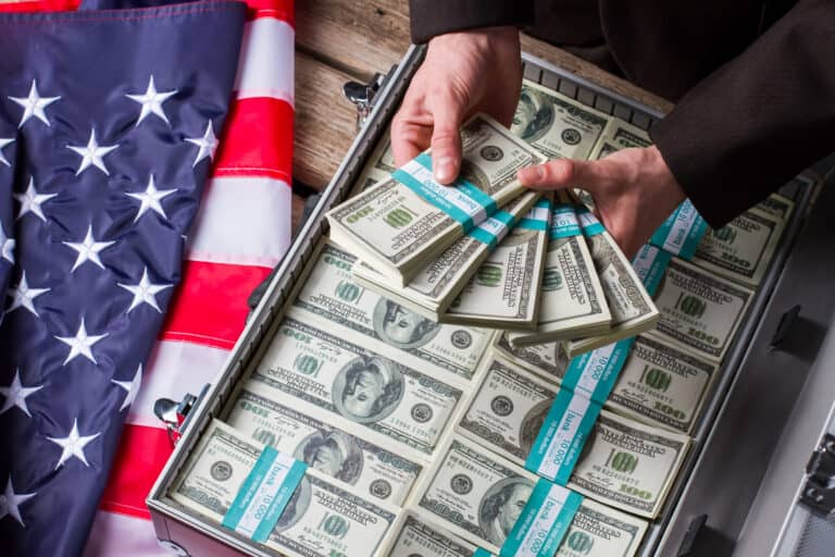 Male hands holding dollar bundles. Hands, money and american flag. Wealth and power. Income of successful politician. Cash / Money.