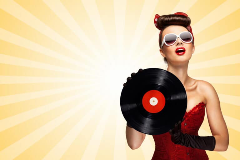 Vintage photo of glamorous pinup girl wearing long gloves and dressed in a red sexy corset, holding LP vinyl record on colorful abstract cartoon style background.