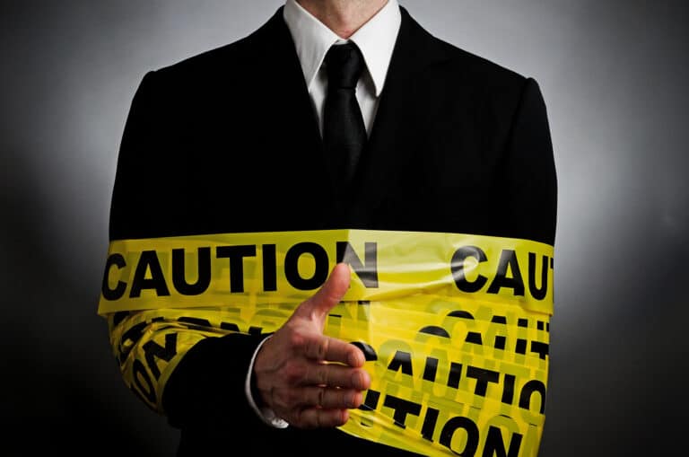 Caution tape wrapped around a business man.