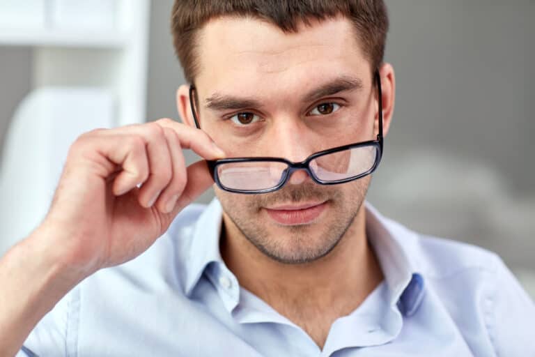 business, people and work concept - portrait of businessman in eyeglasses at office / work