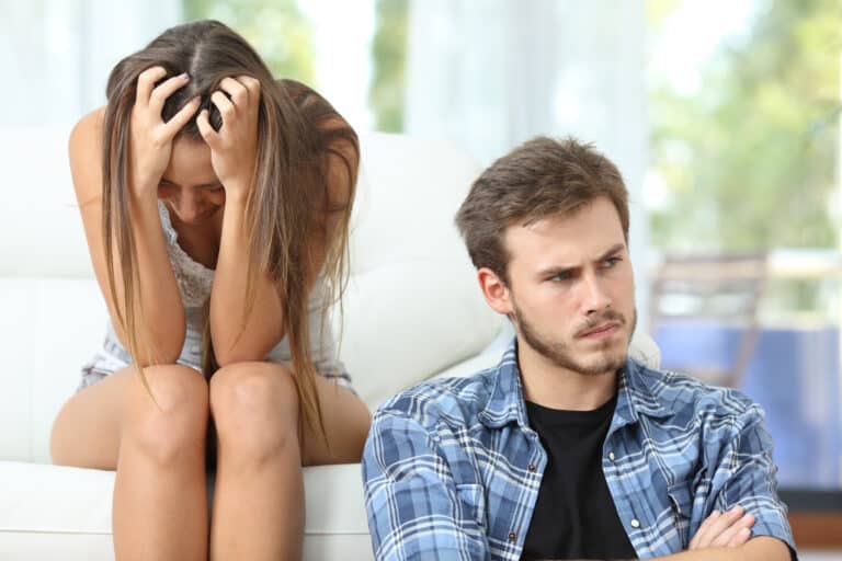 Bad relationship with a couple or marriage angry and sad after argument sitting on a couch at home