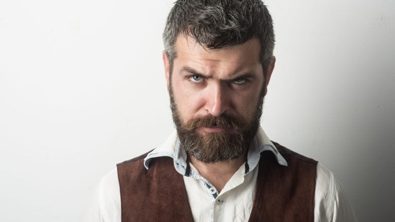 Barber fashion and beauty. Fashion model with stylish hair isolated on white. Man with long beard and mustache on serious face. Hipster in shirt and waistcoat. Guy or bearded businessman.