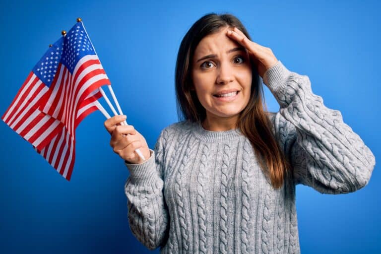 Young patriotic woman holding usa flag on independence day 4th of july over blue background stressed with hand on head, shocked with shame and surprise face, angry and frustrated. Fear and upset for mistake.
