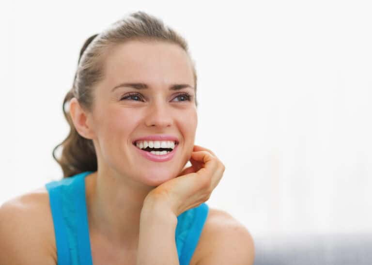 Portrait of smiling young woman sitting in living room