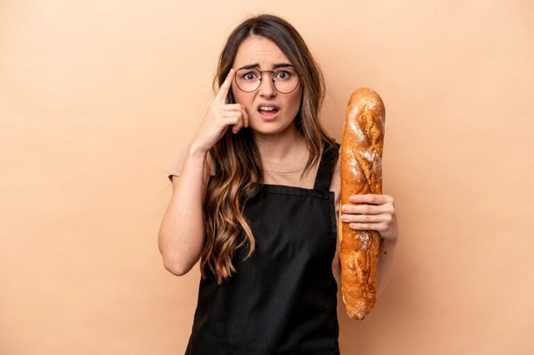 Young baker woman isolated on beige background