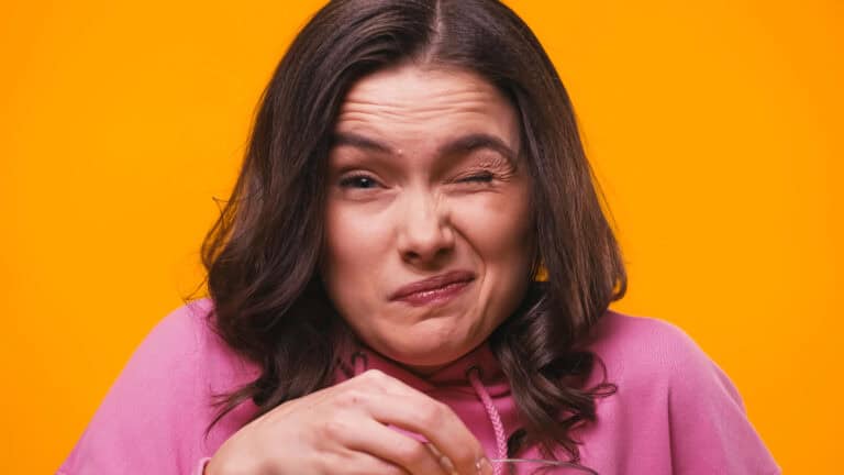 Frightened woman grimacing while looking at camera