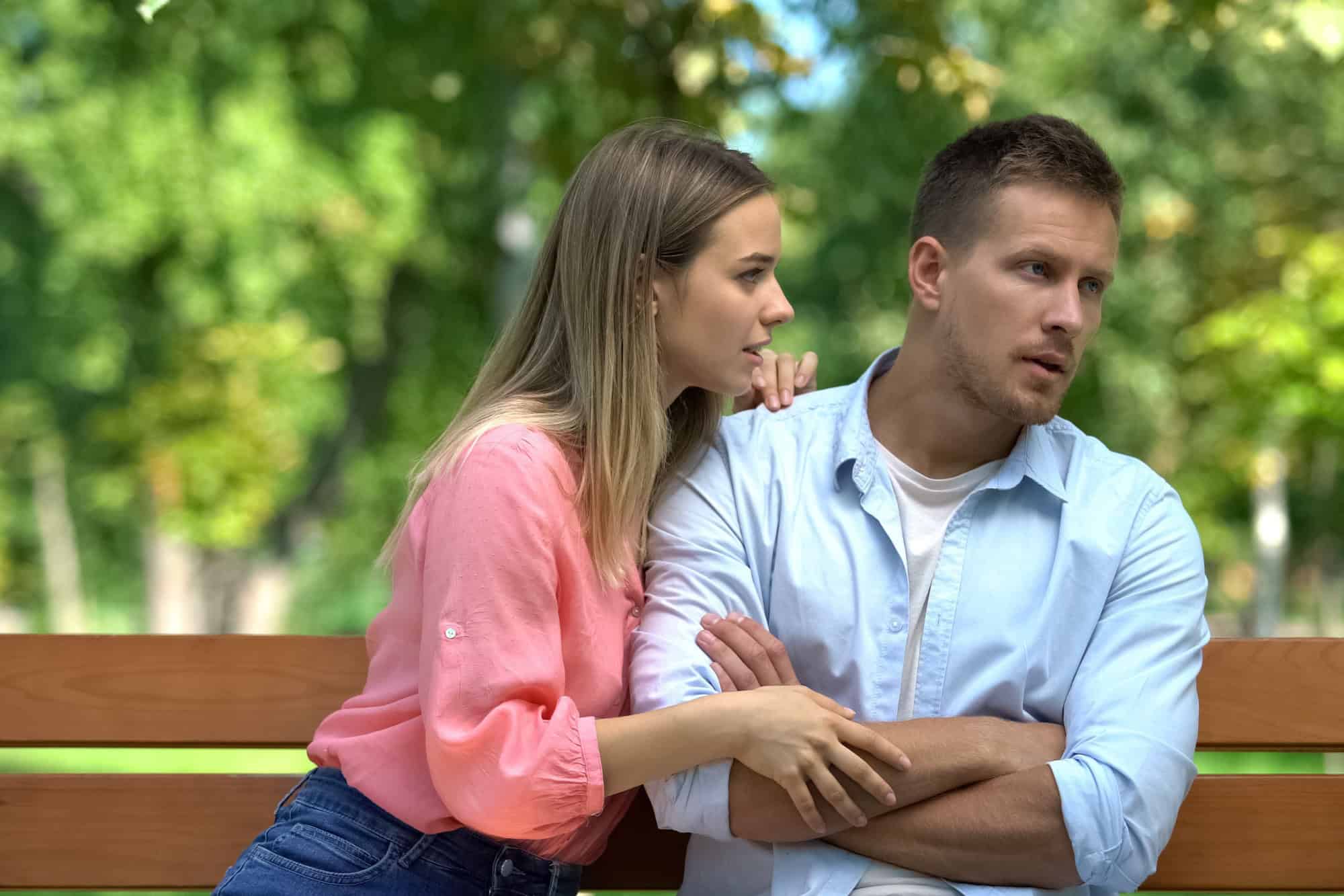 Apologizing woman hugging offended man, reconciliation attempt, couple conflict, rejection