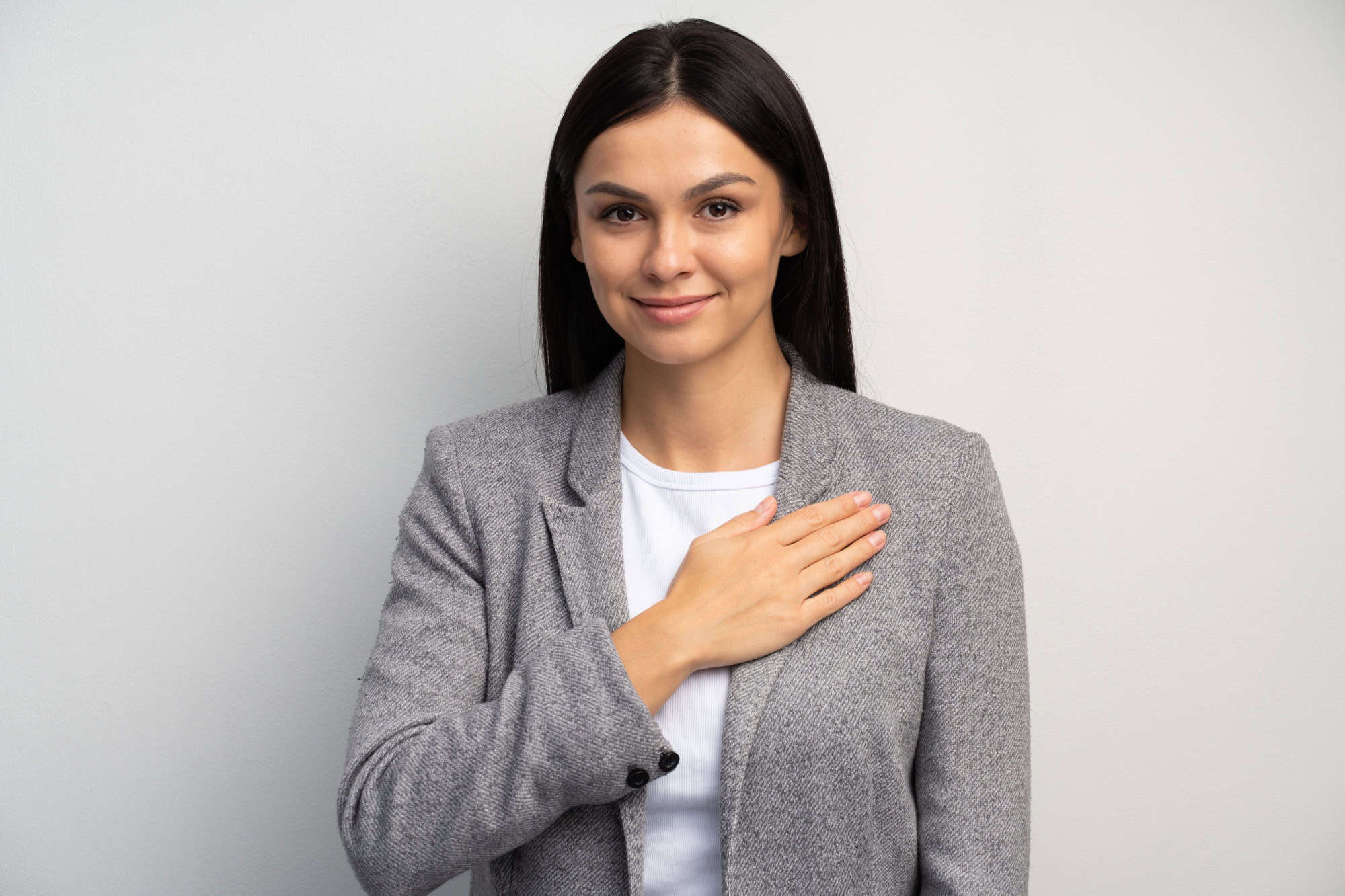I swear. Portrait of responsible serious businesswoman in business suit holding hand to take oath, promising to be honest, telling truth, pledging allegiance. Studio shot isolated on white background