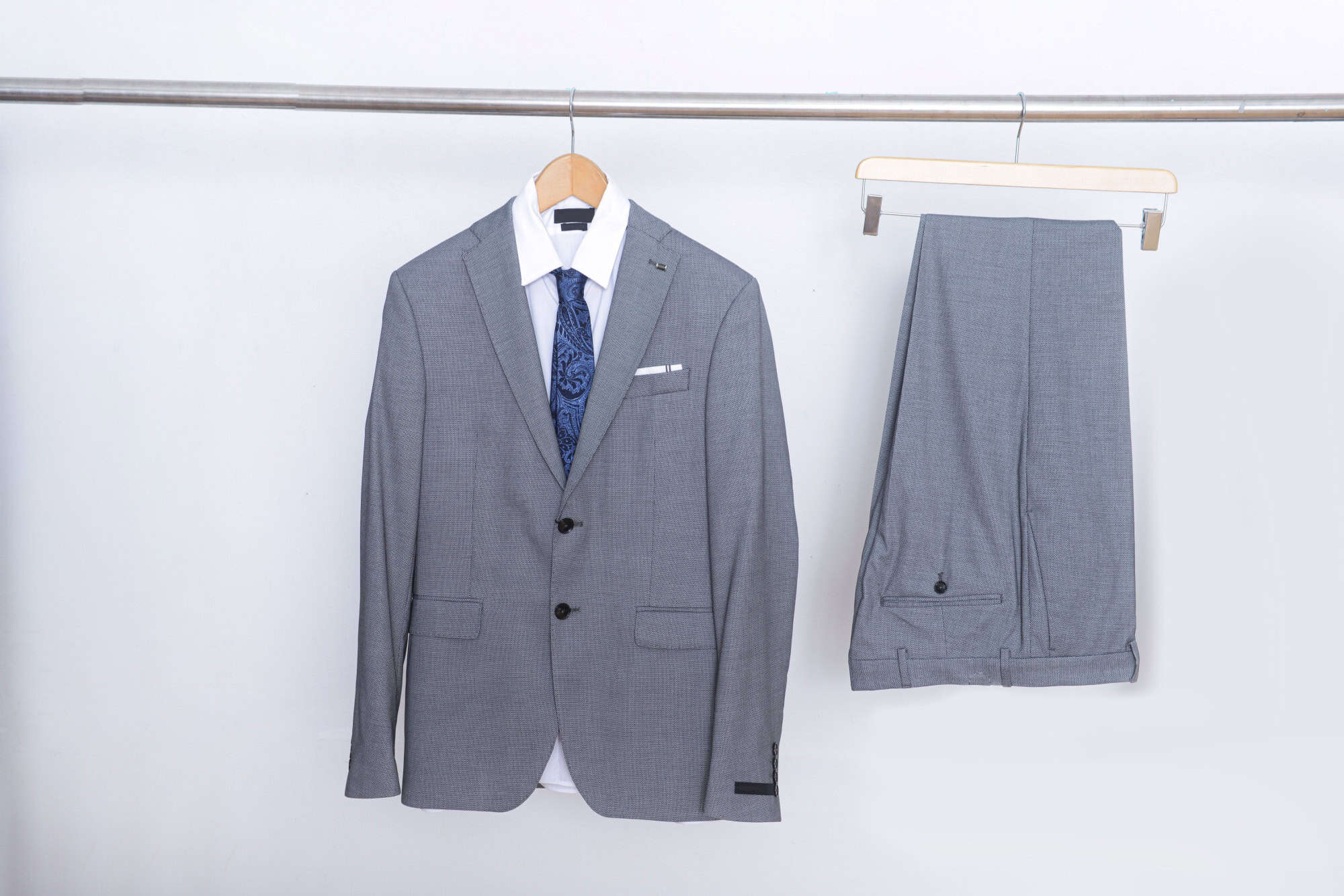 Business formal suit jacket and white ,tie , shirt and gray pants on hanger