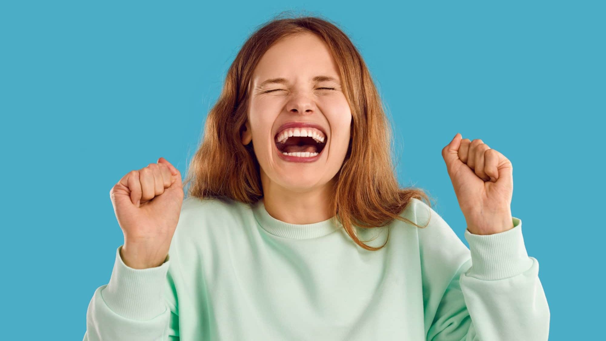 Happy young woman with beautiful genuine candid perfect toothy smile laughing with mouth wide open at funny joke. Head shot angry naughty capricious unruly teenage girl throwing tantrum and