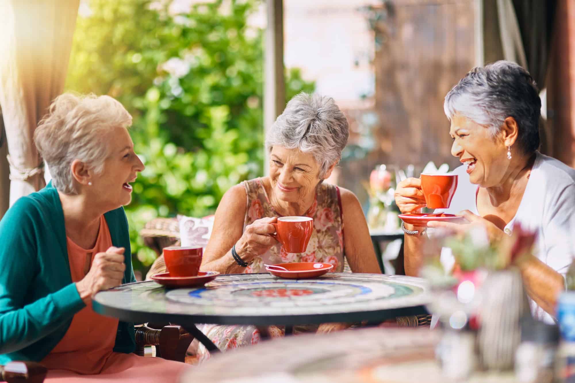 Coffee shop, funny and senior women talking, laughing and having friends reunion, retirement chat or social group. Restaurant, tea and elderly people in happy conversation for pension or cafe cafe