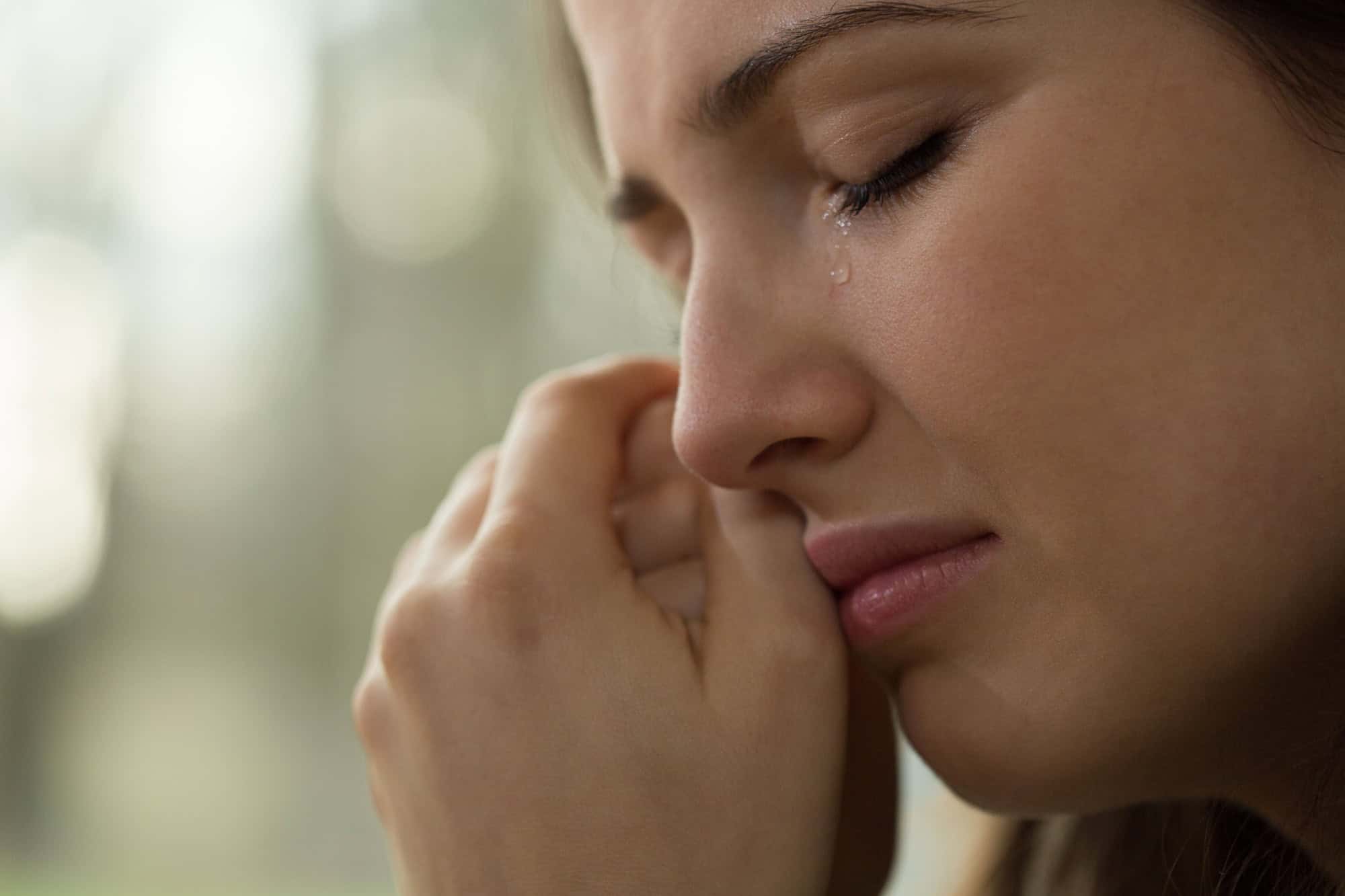 Close-up of young woman with problems crying