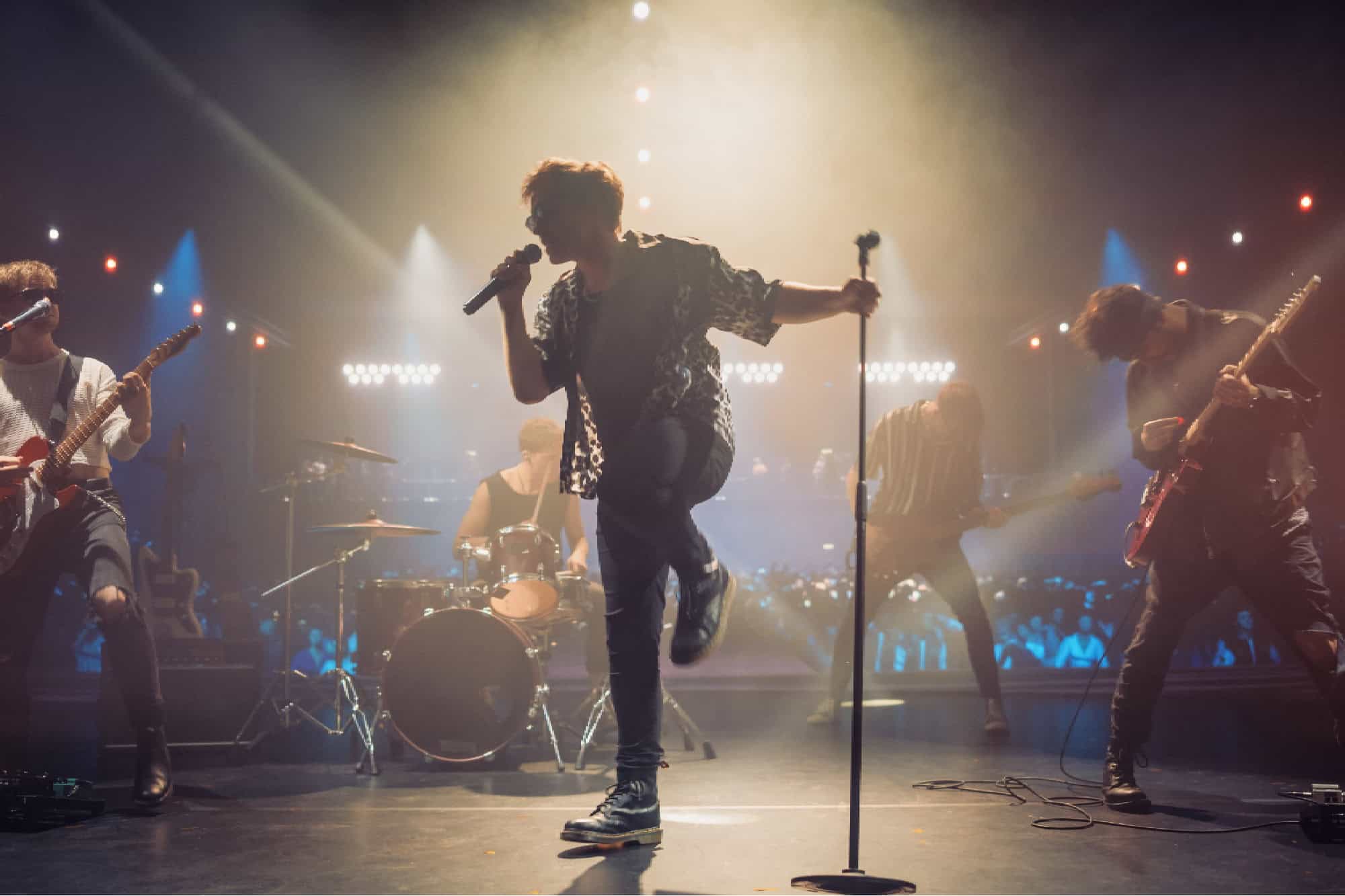 Rock Band Delivers a Captivating Concert with Lead Singer Passionately Performing on Stage with Falling Confetti, Surrounded by Band Members, Creating an Intense and Immersive Musical Atmosphere