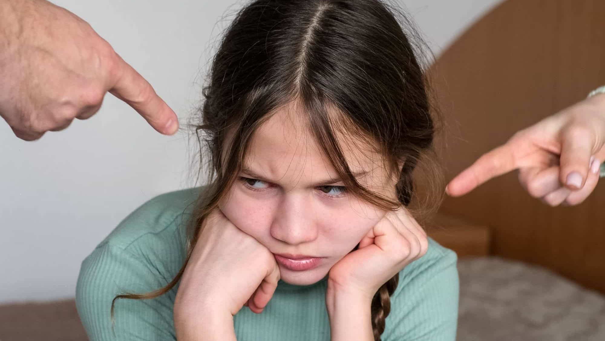 Parents scolding little girl at home. Sad child ignoring them. Kid having bad mood and feeling upset. Family conflict