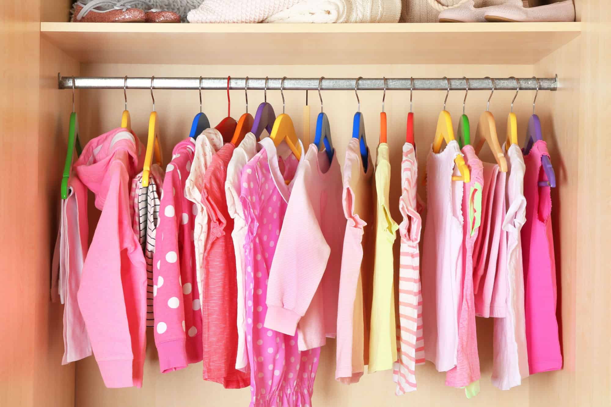 Girl's clothes on hangers in the wardrobe