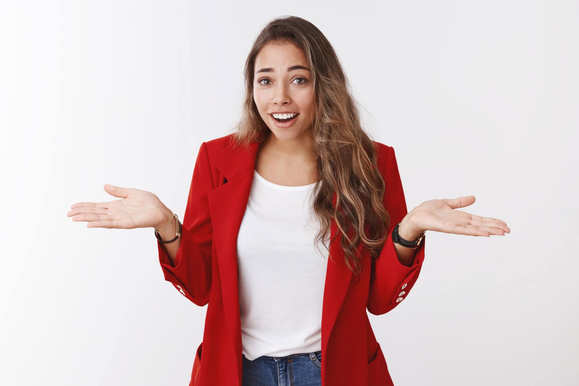 So what. Portrait of arrogant unbothered good-looking modern young stylish woman red jacket, shrugging careless hands sideways smiling gasping indifferent, telling something obvious