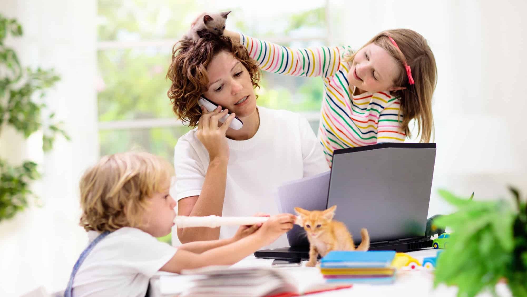 Mother working from home with kids. Quarantine and closed school during coronavirus outbreak. Children make noise and disturb woman at work. Homeschooling and freelance job. Boy and girl playing.