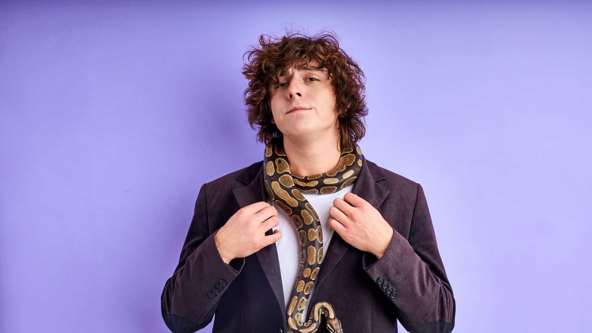 confident man in suit stand with snake on his neck, he is not afraid of anything in this life and he is ready for anything, brave and strong