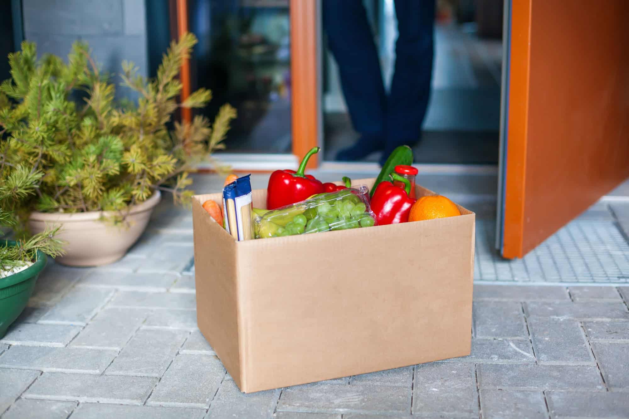 Man customer accepting box with food. Delivery during a pandemic covid-19. Stay at home. Online shopping. Contactless delivery.