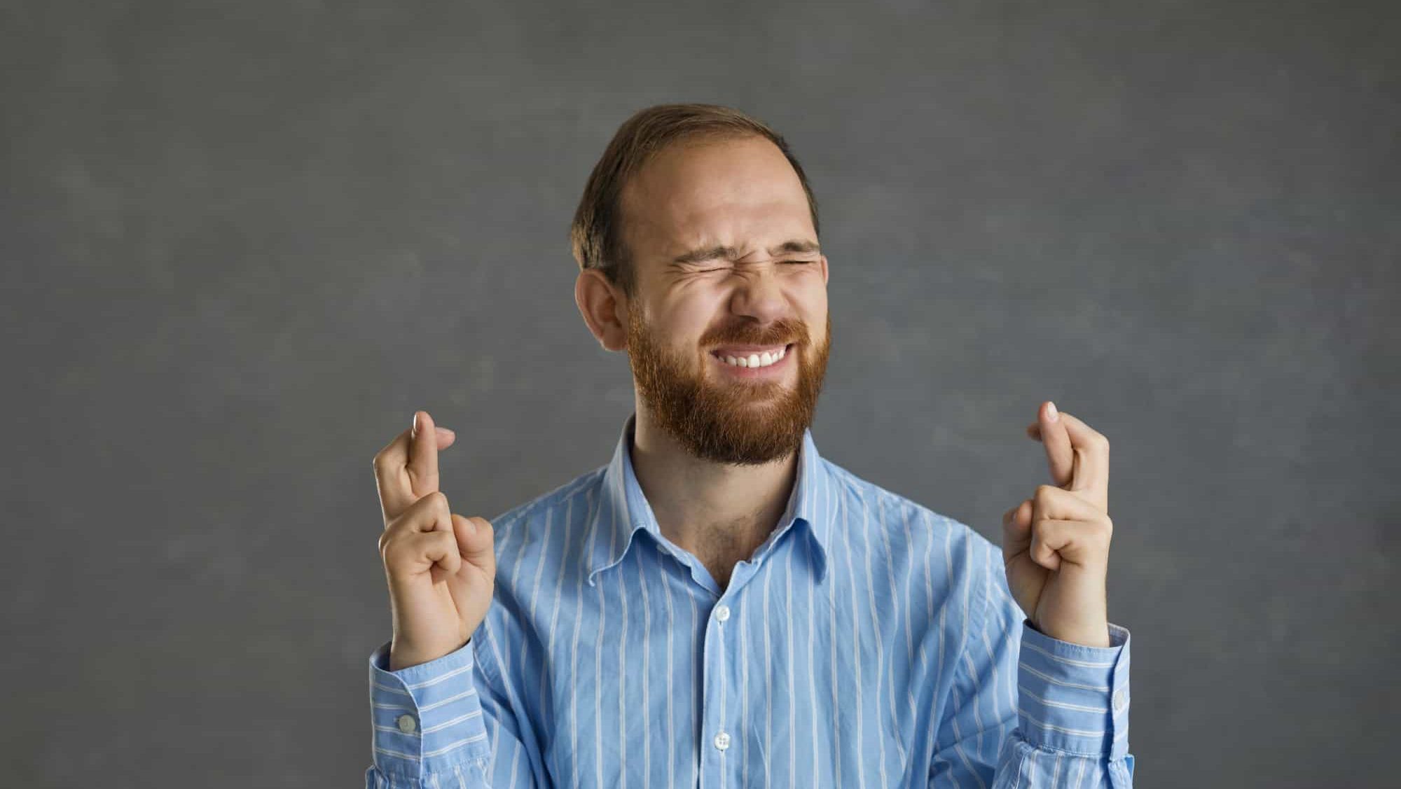 Please, let me get this job. Funny young business man or college student in office shirt asking god to make his wish come true, keeping fingers crossed, believing in luck and hoping for the best