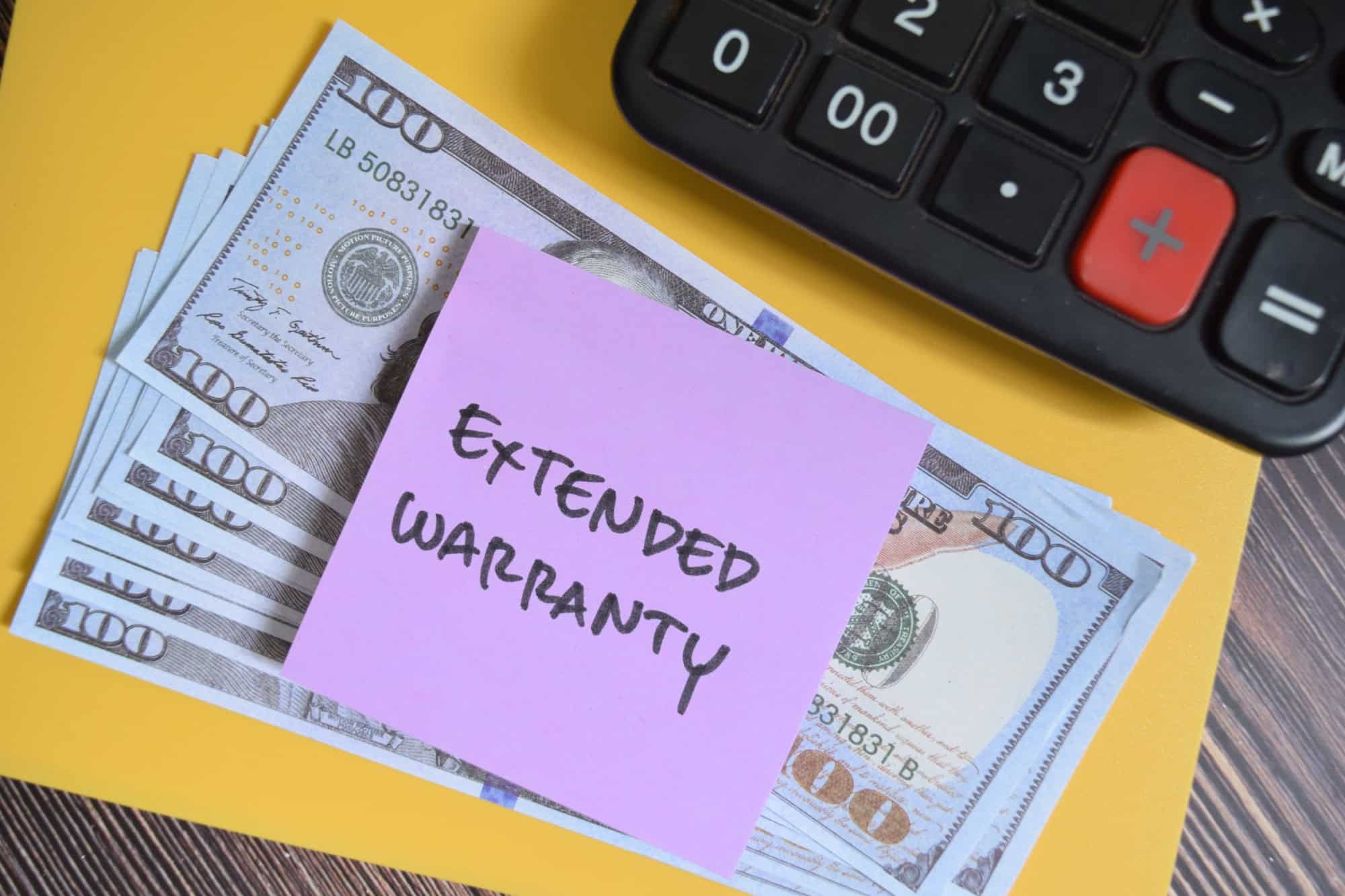 Concept of Extended Warranty write on sticky notes isolated on Wooden Table.