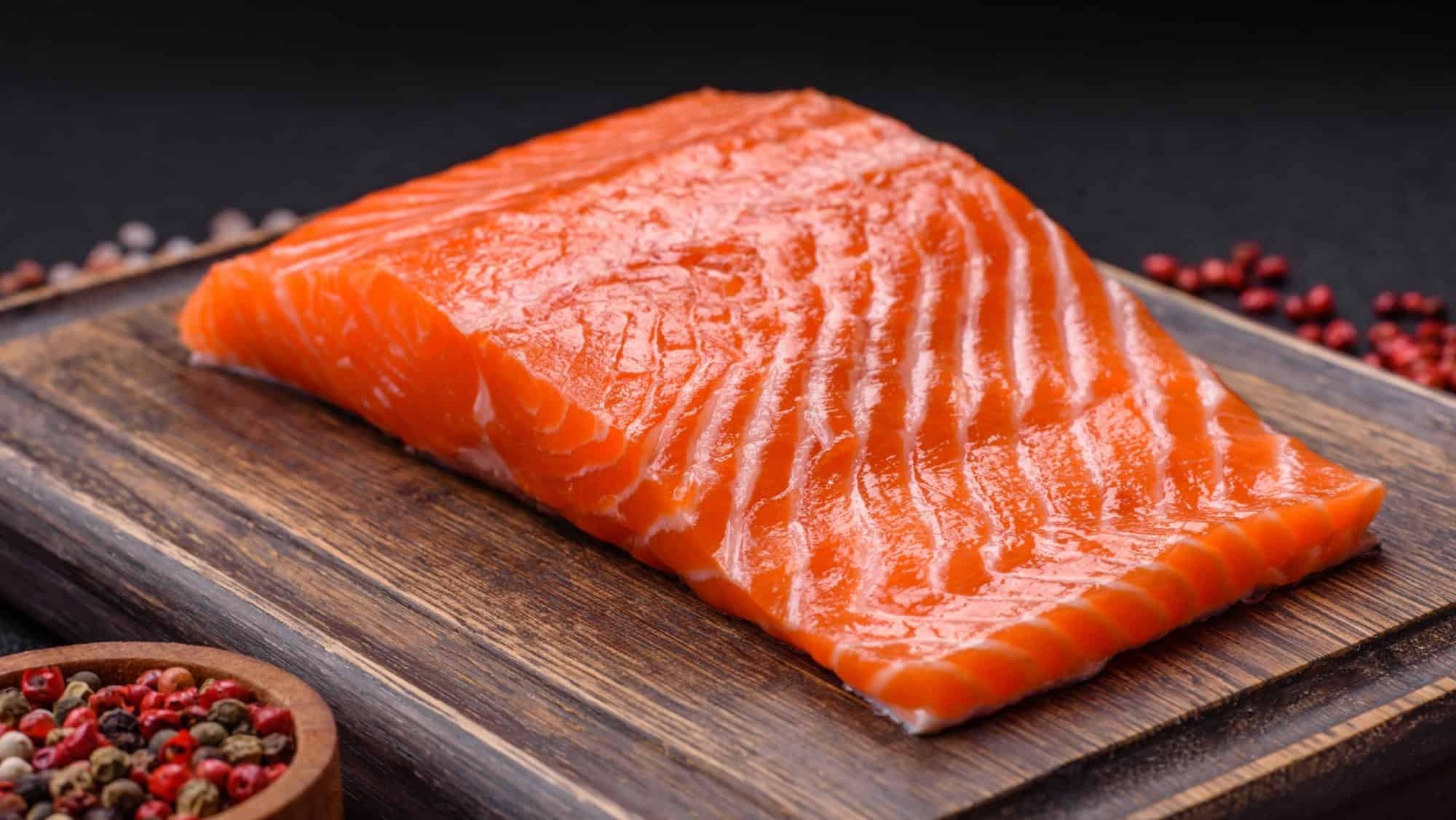 Fresh raw salmon steak with spices and herbs prepared for grilled baking. Healthy seafood food