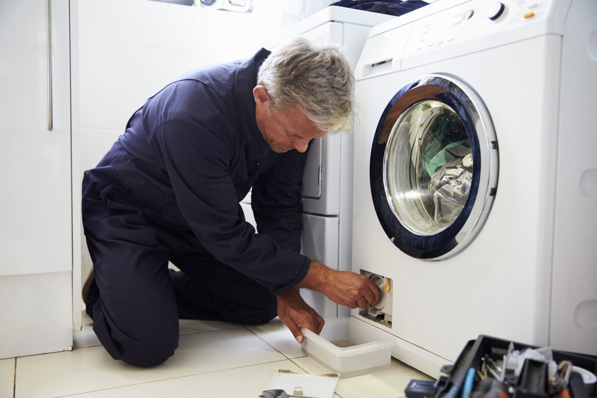 Plumber Fixing Domestic Washing Machine