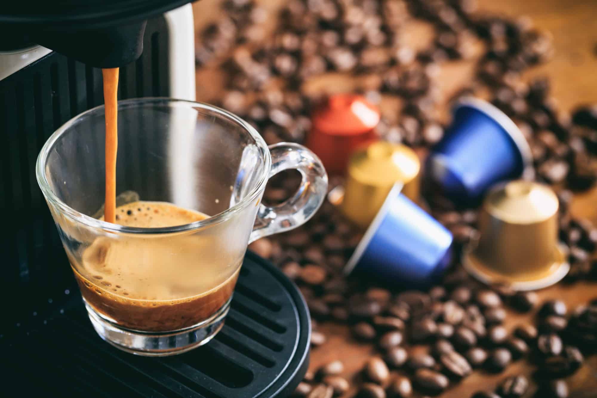 Espresso coffee maker and capsules on a wooden table