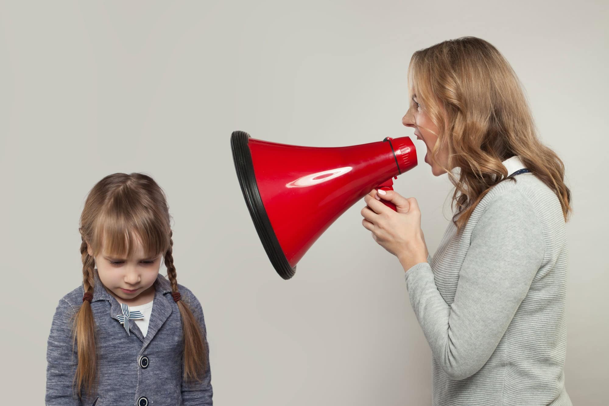 Child abuse concept. Parent abusing kid, mother shouting in loudspeaker to sad daughter