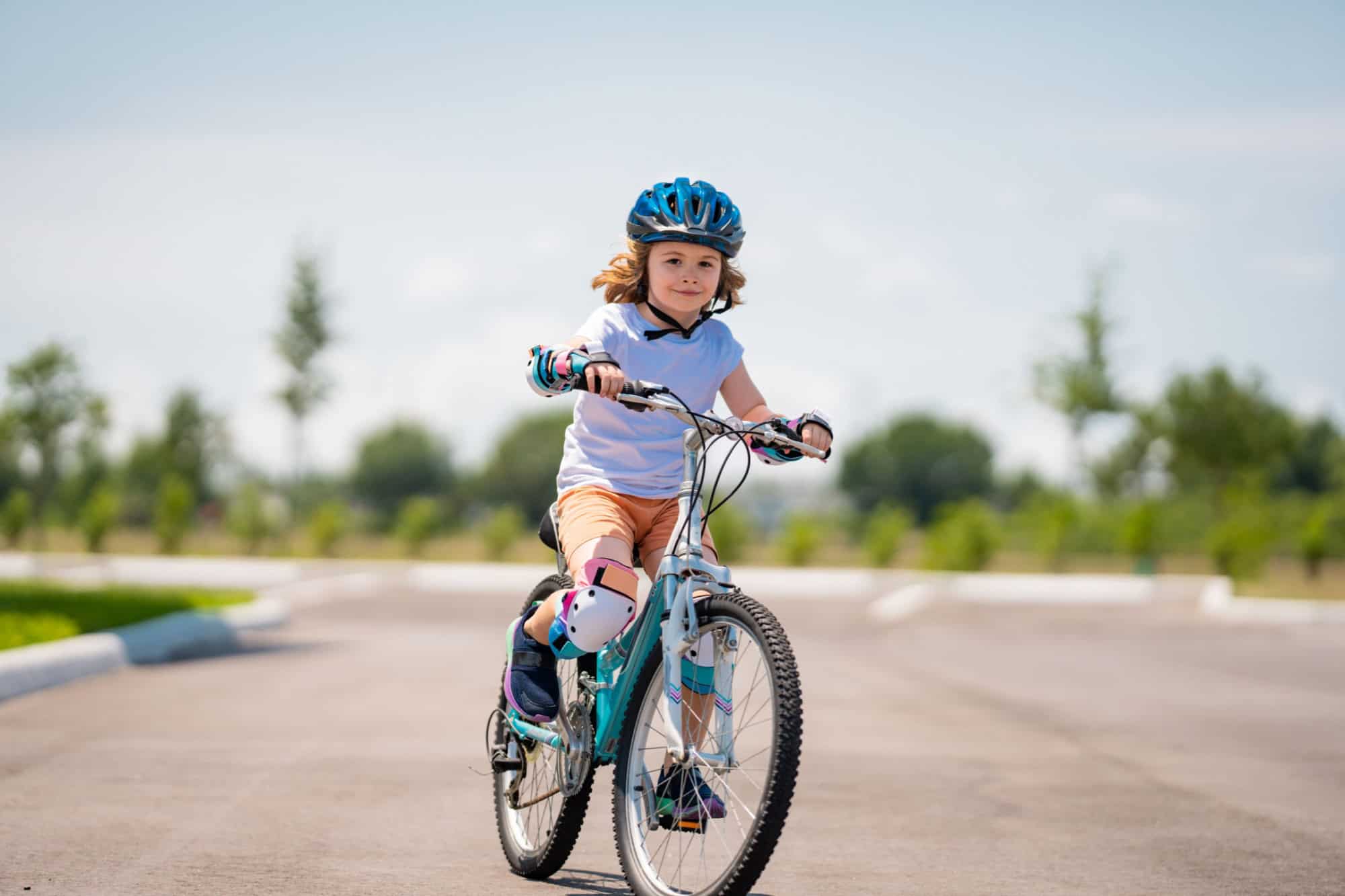 Child in safety helmet riding bike. Boy riding bike wearing a helmet outside. Child in safety helmet riding bike. Little kid boy learns to ride a bike. Kid on bicycle.