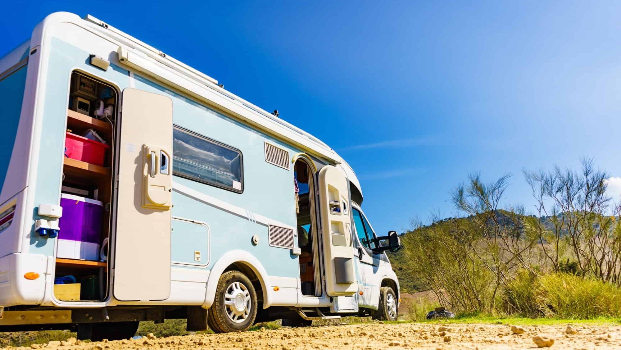 Camper rv with open storage box camping on nature, Spain. Adventure with motor home.