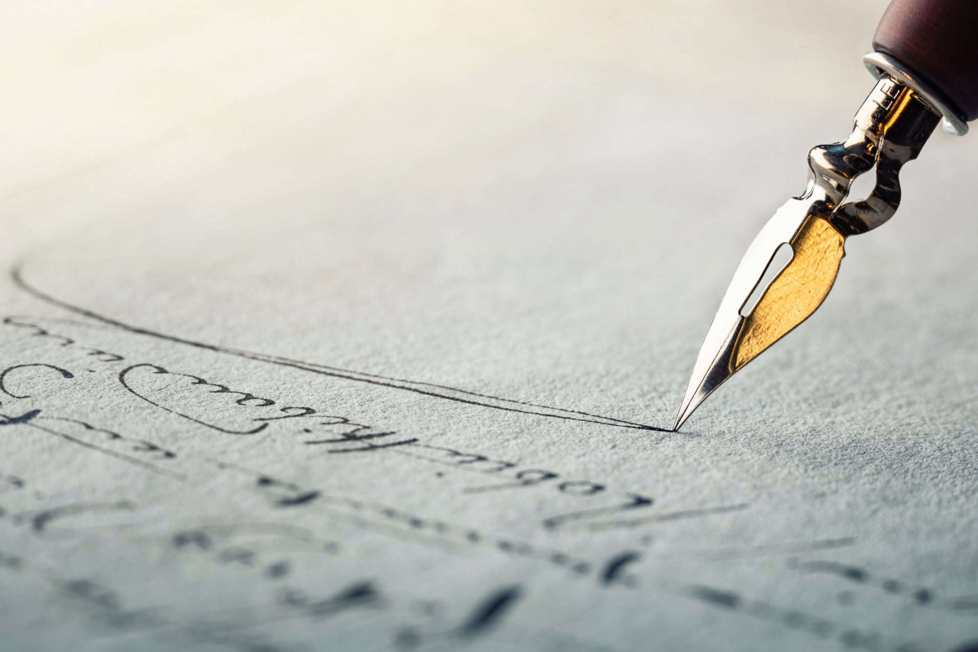 Fountain pen on an antique handwritten letter. Vintage nib pen and handwritten english cursive style font copperplate, spencerian. Old history background. Retro style.