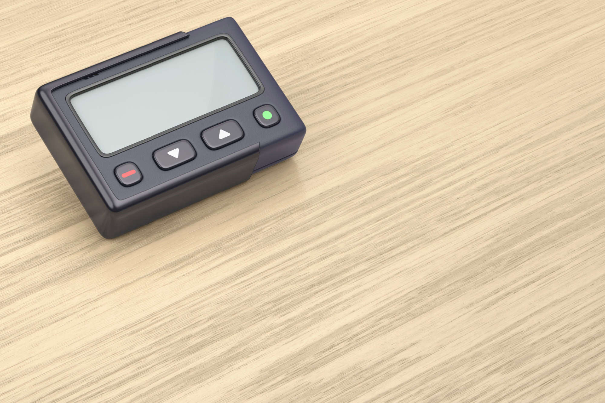 Retro pager with blank screen on wooden desk