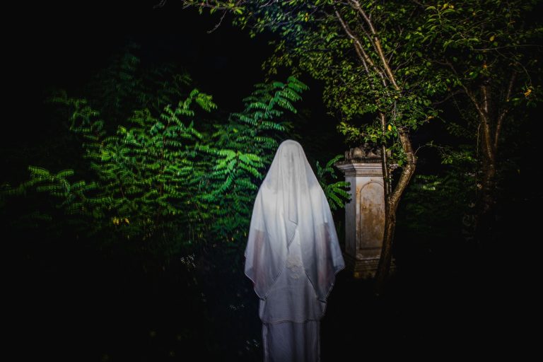 Scary ghost in cemetery at night Halloween background