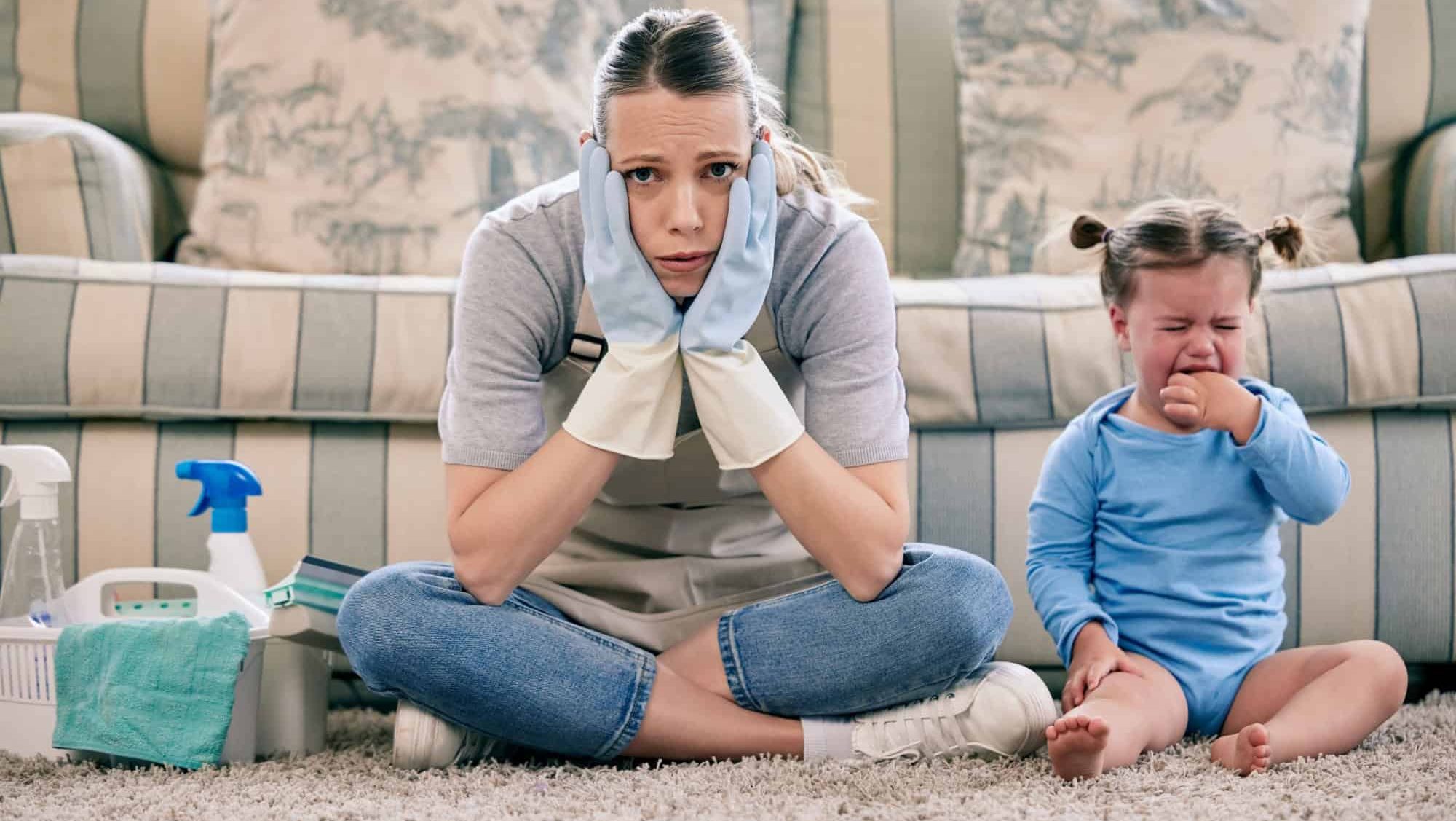 Woman, chores and crying baby in home, portrait and stress for multitasking, gloves or spring cleaning. Overwhelmed, mother and daughter with screaming, frustrated or basket on carpet in family house
