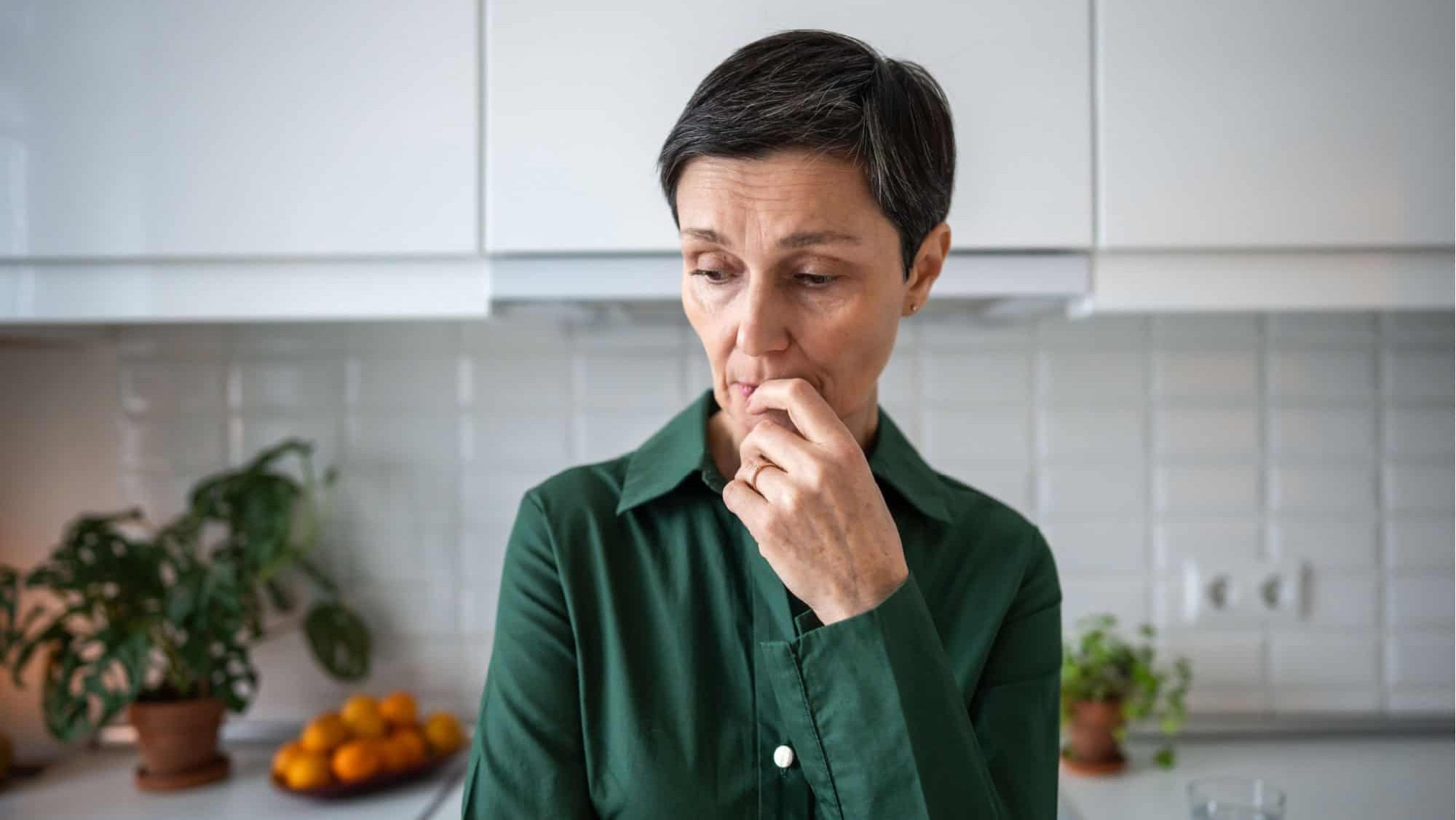 Worried nervous woman deep in contemplation, melancholy and distress. Solitude, personal crisis, depressive feelings, unresolved issues, silent suffering, mental fatigue, senior crisis and loneliness
