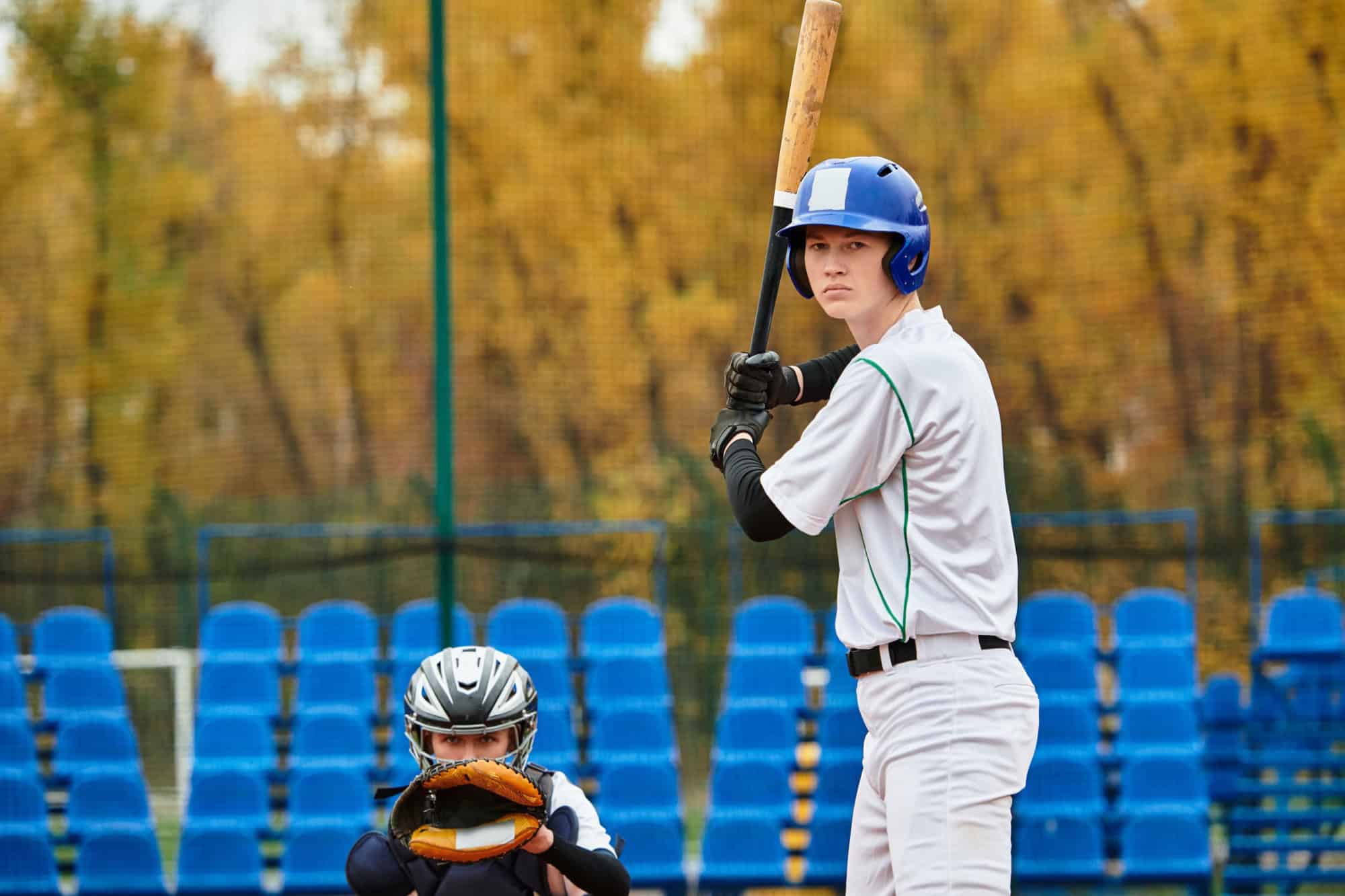 Two teens play an exciting baseball game, showing off their skills on a vibrant field.