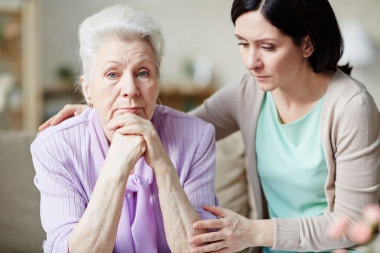 Young woman comforting her discontent or offended aged mother