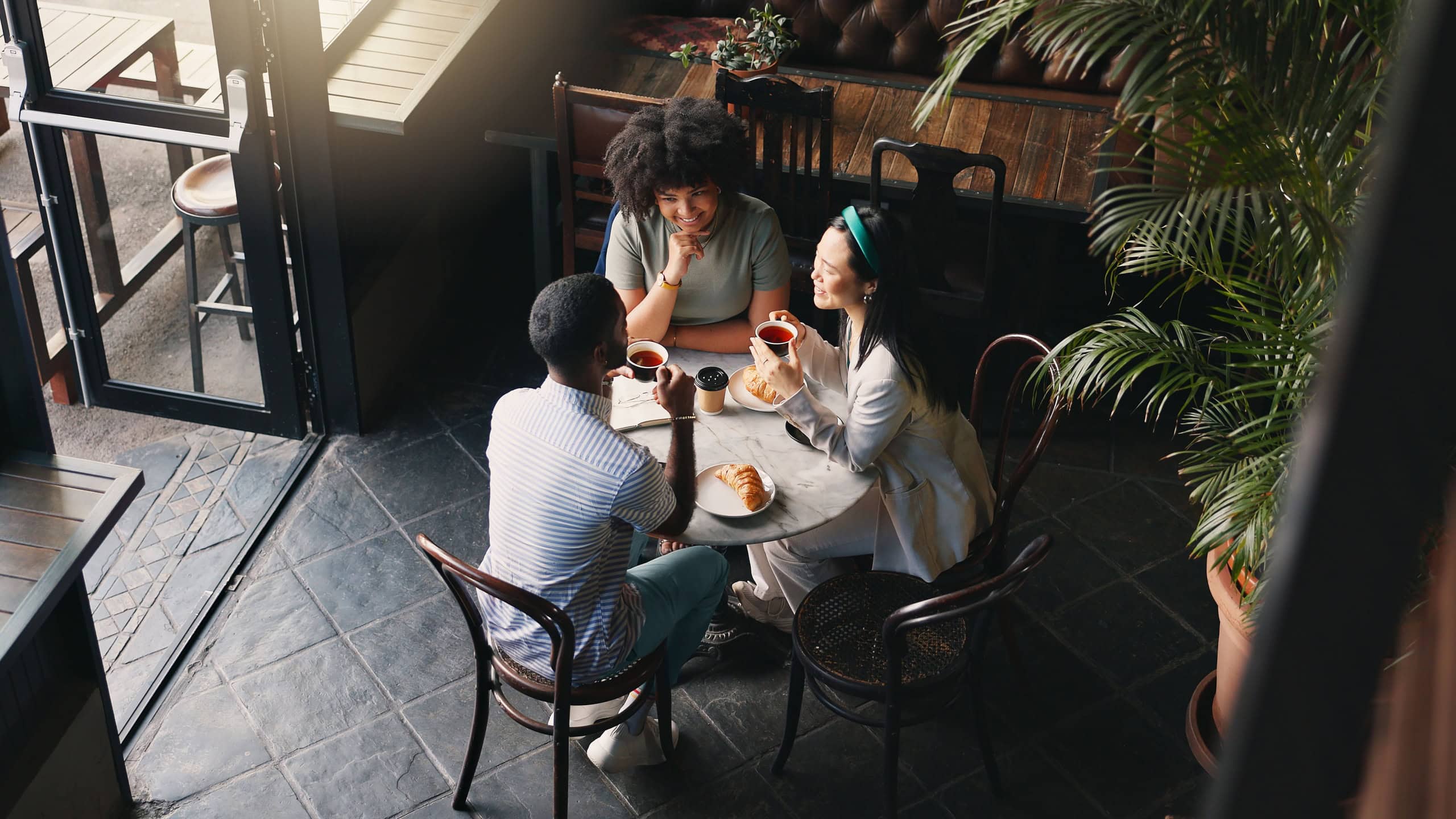 Friends, group and talking in coffee shop for communication catch up or university reunion, gossip or pastry, Man, woman and chat in cafe together as consumer for bonding lunch, diversity or social