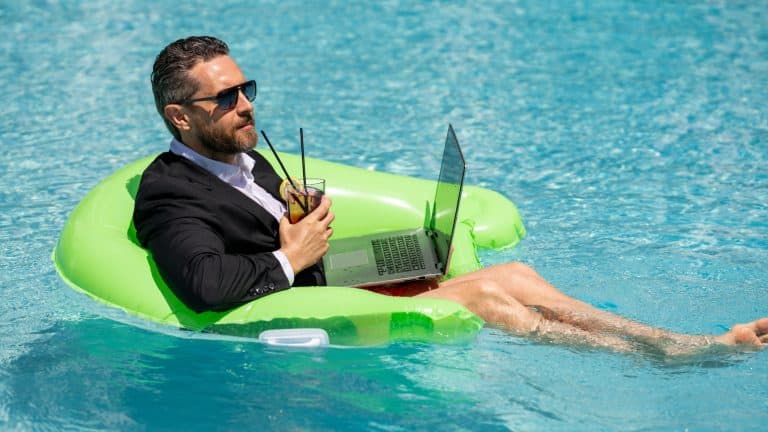 Funny business man relaxing in suit on swimming pool. Summer vacation, business on sea beach. Summer rest, business people concept. Wealthy business man relaxing in swimming pool. Remote on-line work.
