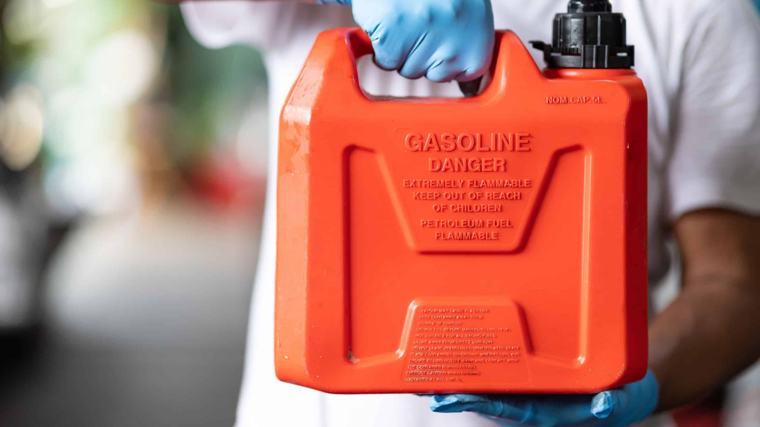 man handle red plastic fuel gallon flammable material container for refill gasoline car tank