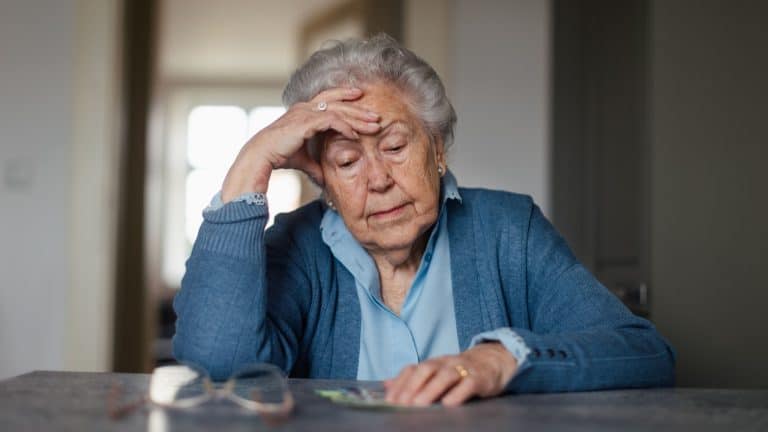 Senior woman counting her money at home.