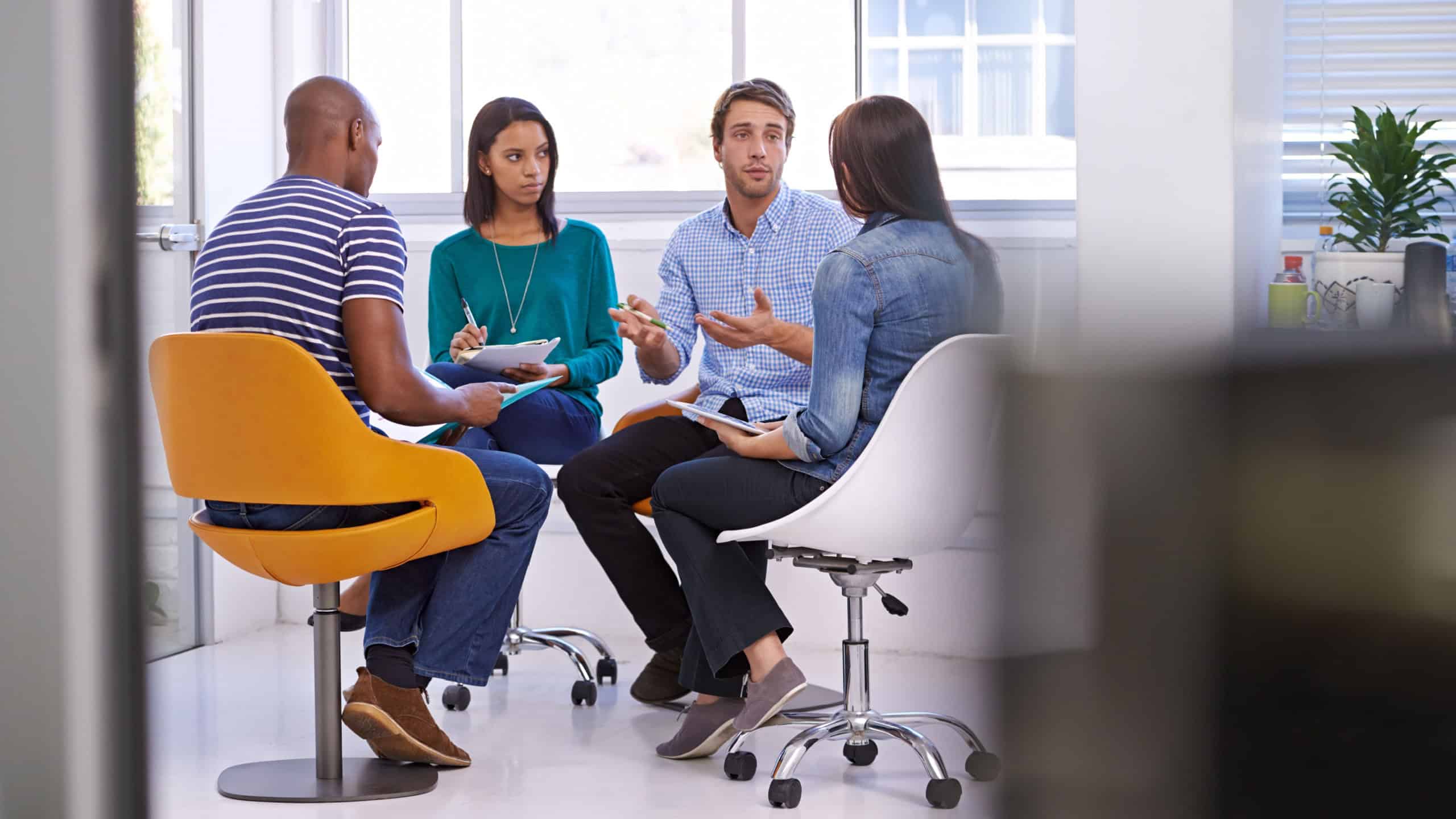 Business people, speaker and team planning, discussion or brainstorming ideas together in startup. Diverse group, paperwork and creative designers in collaboration, cooperation and serious in meeting