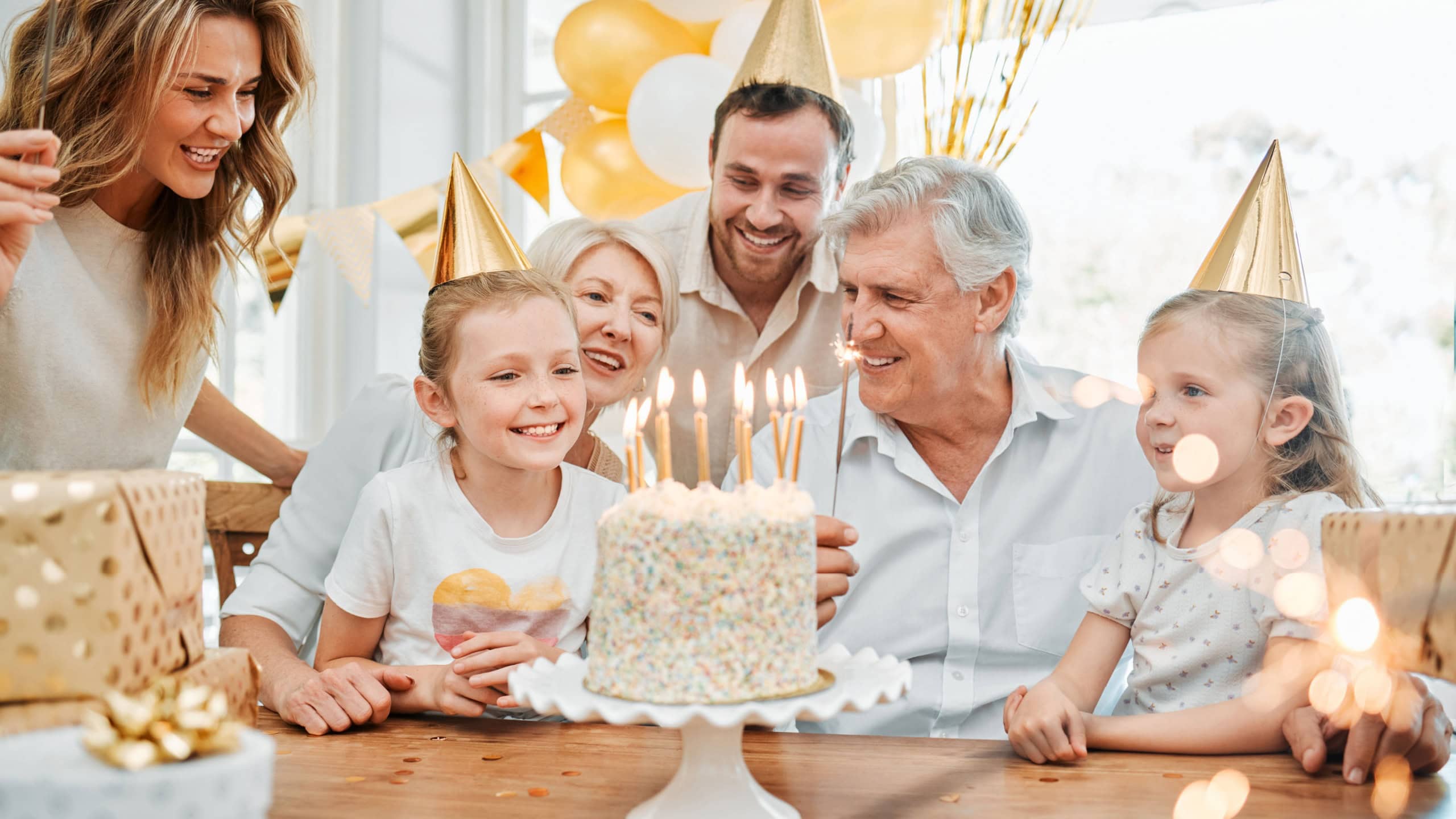 Love, party and family to celebrate birthday in home, support and happiness at event for cake. People, generations and proud of milestone, bonding and love for growing girl, parents and grandparents